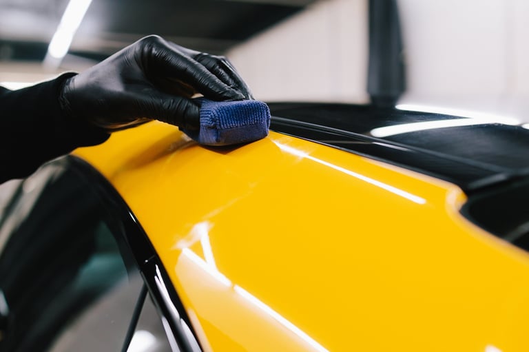 Process of applying a ceramic coating to the sports car surface for protection during detailing session at the service